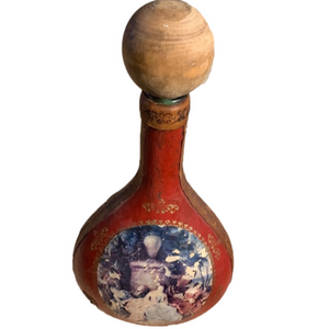 Red leather wrapped liquor bottle with picture on the front and gold detailing.